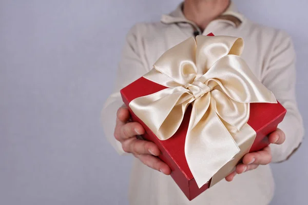 Man holding red present with white Ribbon close up . Gift box. Love, Birthday, New year, Valentine's Day, 8 march, Christmas concept. — Stock Photo, Image