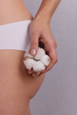 Pamuk külot giyiyor ve pamuk çiçek tutan kadın kapatın. Kadın iç çamaşırı doğal organik malzemelerden yapılmış