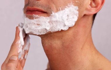 Tıraş köpüğü adam koymak, daha önce o yüzünü tıraş bıçağı ile tıraş jeli. Erkekler Cilt Bakımı kavramı.