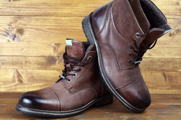 Brown leather winter mens high boots, shoes on vintage wooden background — Stock Photo, Image