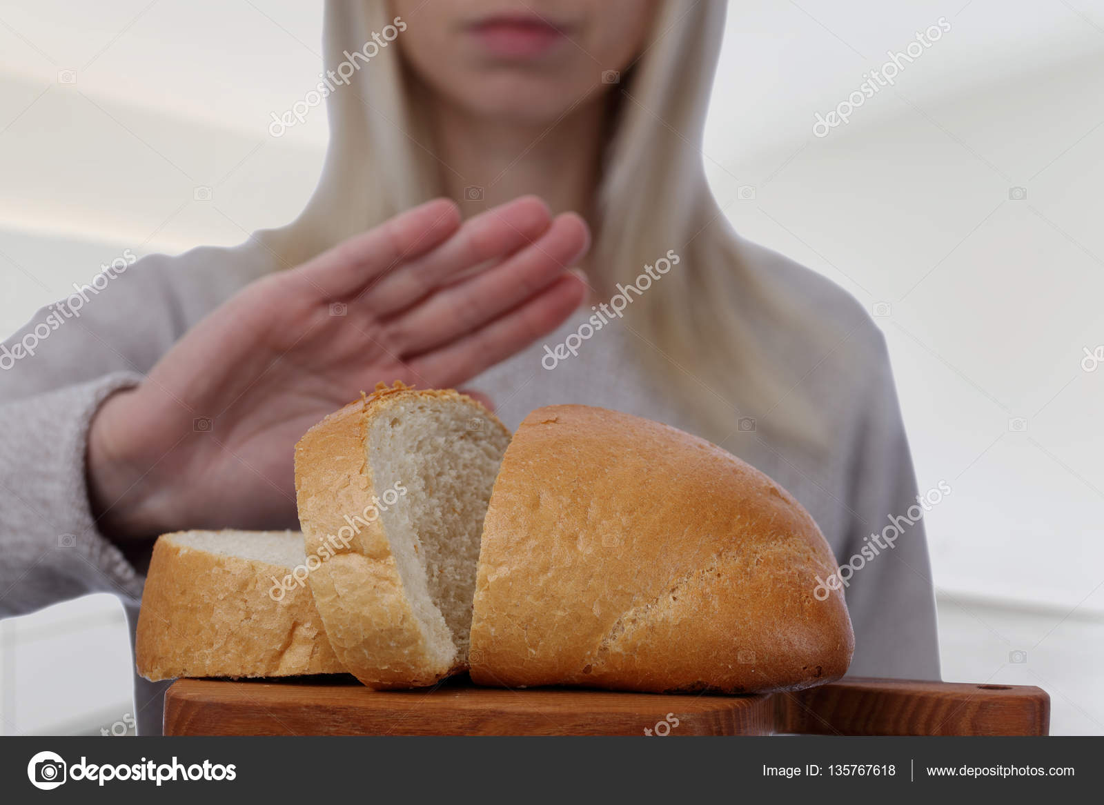 Gluten intolerance and diet concept. Woman refuses to eat white bread. Selective focus on bread