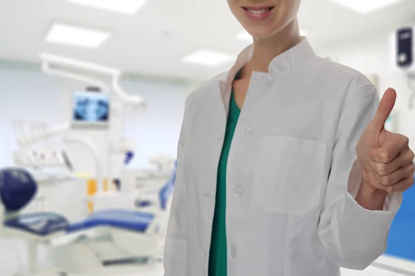 Médica dentista sorridente a mostrar o polegar para cima. Conceito de cuidados de saúde oral — Fotografia de Stock
