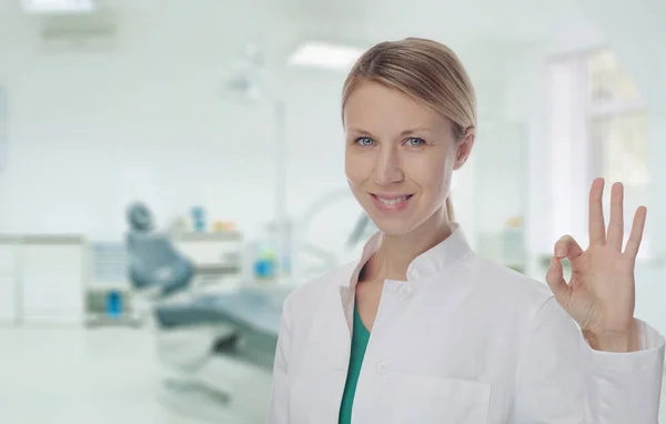 Усміхнене жіночий лікар стоматолог показ ОК або Alright знак. — стокове фото