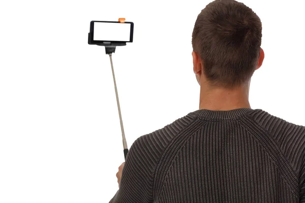 Un barbat care face un selfie cu telefonul mobil, celular si selfie stick izolat pe alb — Fotografie, imagine de stoc