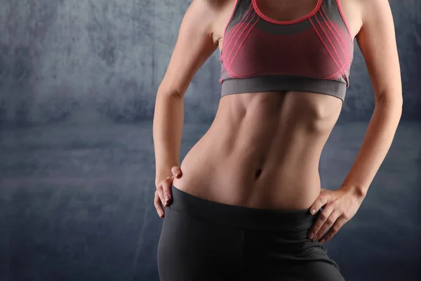 Sport, fit vrouw. Meisje met perfecte buik spieren op een grijze achtergrond. Dieet, fitness, actieve levensstijl concept, kopiëren ruimte — Stockfoto