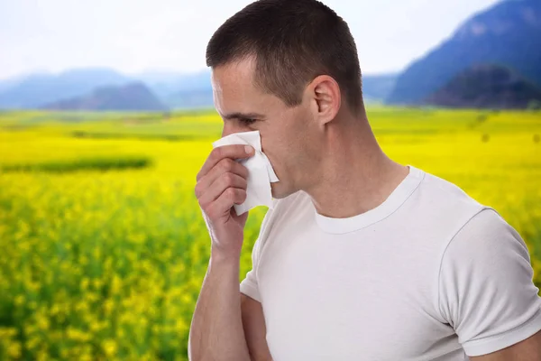 Pollen allergy, Springtime. Man sneezing in a tissue — Stock Photo, Image