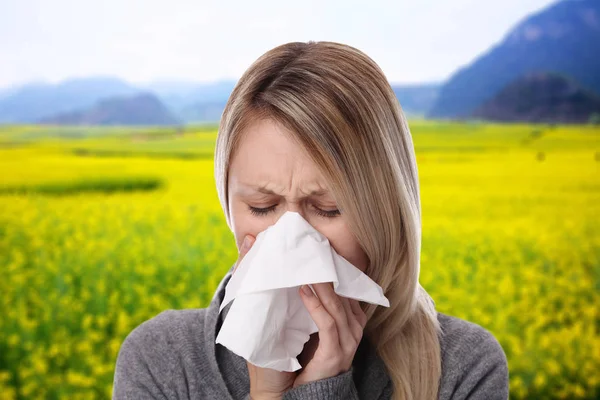 Аллергия на пыльцу, весна. Женщина чихает в салфетке — стоковое фото