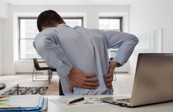 Business man with back pain in an office . Pain relief concept — Stock Photo, Image