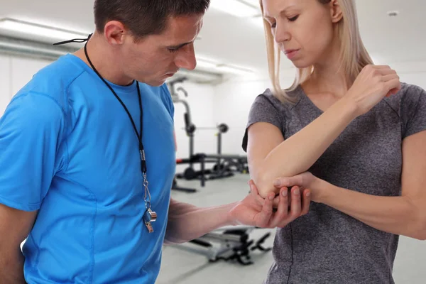 Sport kvinna med armbågen smärta i gymmet. Sport utövar skada. — Stockfoto