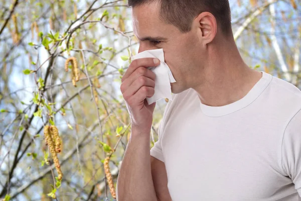 Pollen allergy, Springtime. Man sneezing in a tissue — Stock Photo, Image