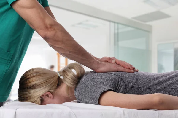 У женщины коррекция спины с помощью хиропрактики. Остеопатия, Альтернативная медицина, концепция обезболивания. Физиотерапия, реабилитация спортивных травм — стоковое фото