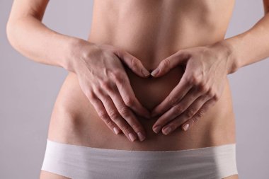 Kadın karnında kalp şekil verme. Sağlıklı kadın vücut, bel. İnce kadın gövde, bel, göbek, karın kadar yakın. Spor, fitness, diyet sonuçları, aktif yaşam tarzı kavramı