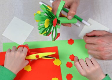 Çocuk renkli kağıt kesti. Çocuk yapma doğum günü kartı. Baba ve oğul hediye anneler günü ya da 8 Mart için hazırlanıyor. Çocuklar sanat projeleri. Mutlu aile kavramı