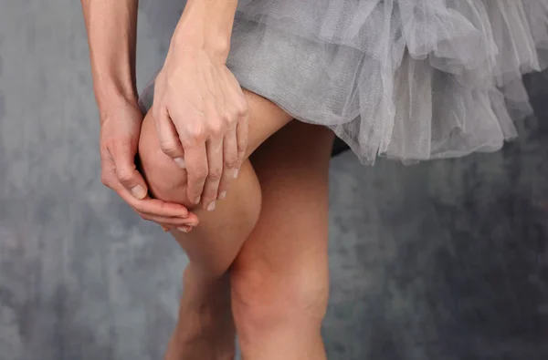 Dolor en las articulaciones. Hermosa bailarina con falda de ballet sosteniendo rodilla lesionada . — Foto de Stock