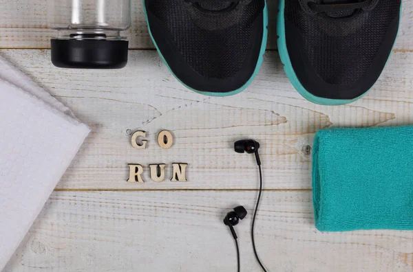 Motivação de corrida Go Run. Fitness Citação inspiradora., sapatos esportivos e garrafa de água no fundo de madeira branca. Conceito de estilo de vida saudável . — Fotografia de Stock