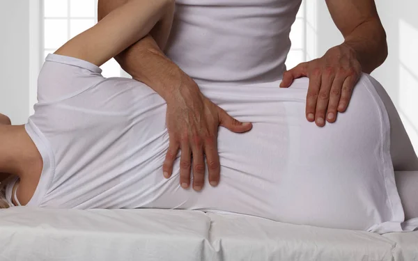 Mujer con ajuste de espalda quiropráctico. Osteopatía, medicina alternativa, concepto de alivio del dolor. Fisioterapia, rehabilitación de lesiones deportivas — Foto de Stock