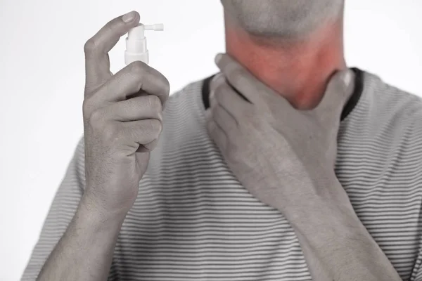 Человек, использующий горловой спрей для устранения инфекции горла, помочь повторно — стоковое фото