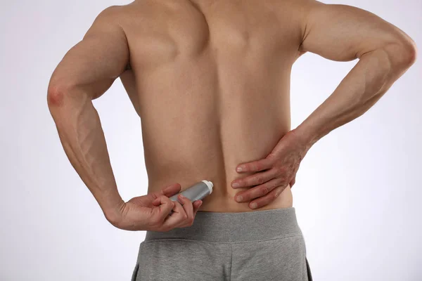 Man applying pain relieving cream, gel. Sport injury, Man with back, neck pain. Pain relief and health care concept. — Stock Photo, Image