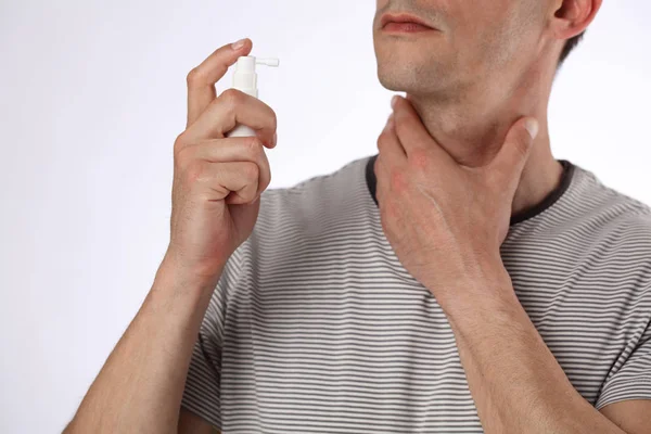 Man using throat spray to eliminate throat infection, help to relieve pain. Healthcare and medical concept — Stock Photo, Image