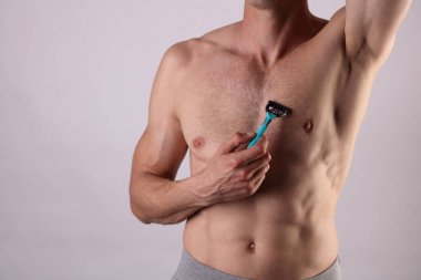 Kaslı erkek torso yakın kadar göğüs ve koltuk altı, koltuk altı epilasyon. Erkek epilasyon. Saç bedeninden çıkarmak için ustura kullanan genç çekici kaslı adam