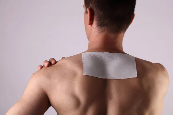 Medicated pain relief patch, plaster. man with back pain. Pain relief and health care concept isolated on white. — Stock Photo, Image