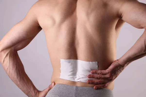 Medicated pain relief patch, plaster. man with back pain. Pain relief and health care concept isolated on white. — Stock Photo, Image