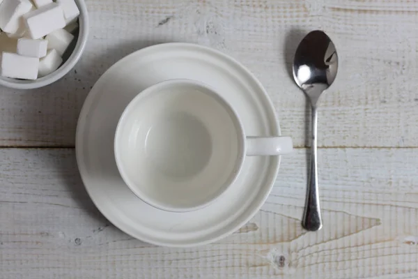 Leerer Tee, Kaffeetasse mit Löffel und Zucker auf rustikalem Holztisch. minimalistischer flacher Hintergrund — Stockfoto