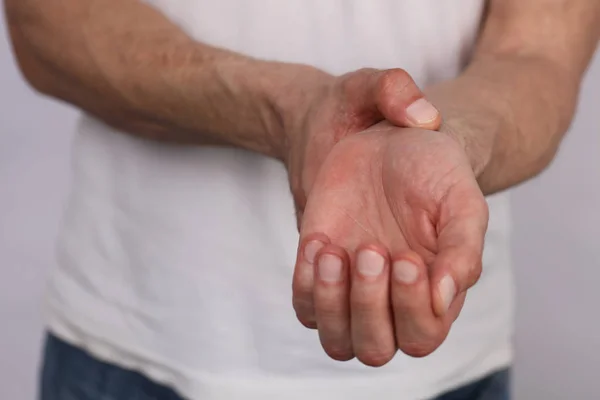 Man hands checking heart rate pulse on wrist close up