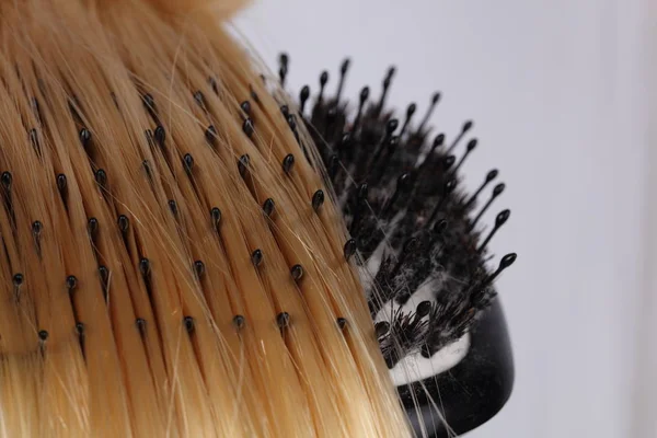 Cabello rubio y cepillo sobre fondo blanco. concepto de salón de peluquería, conjunto de peluquería. Accesorios de corte de pelo . — Foto de Stock