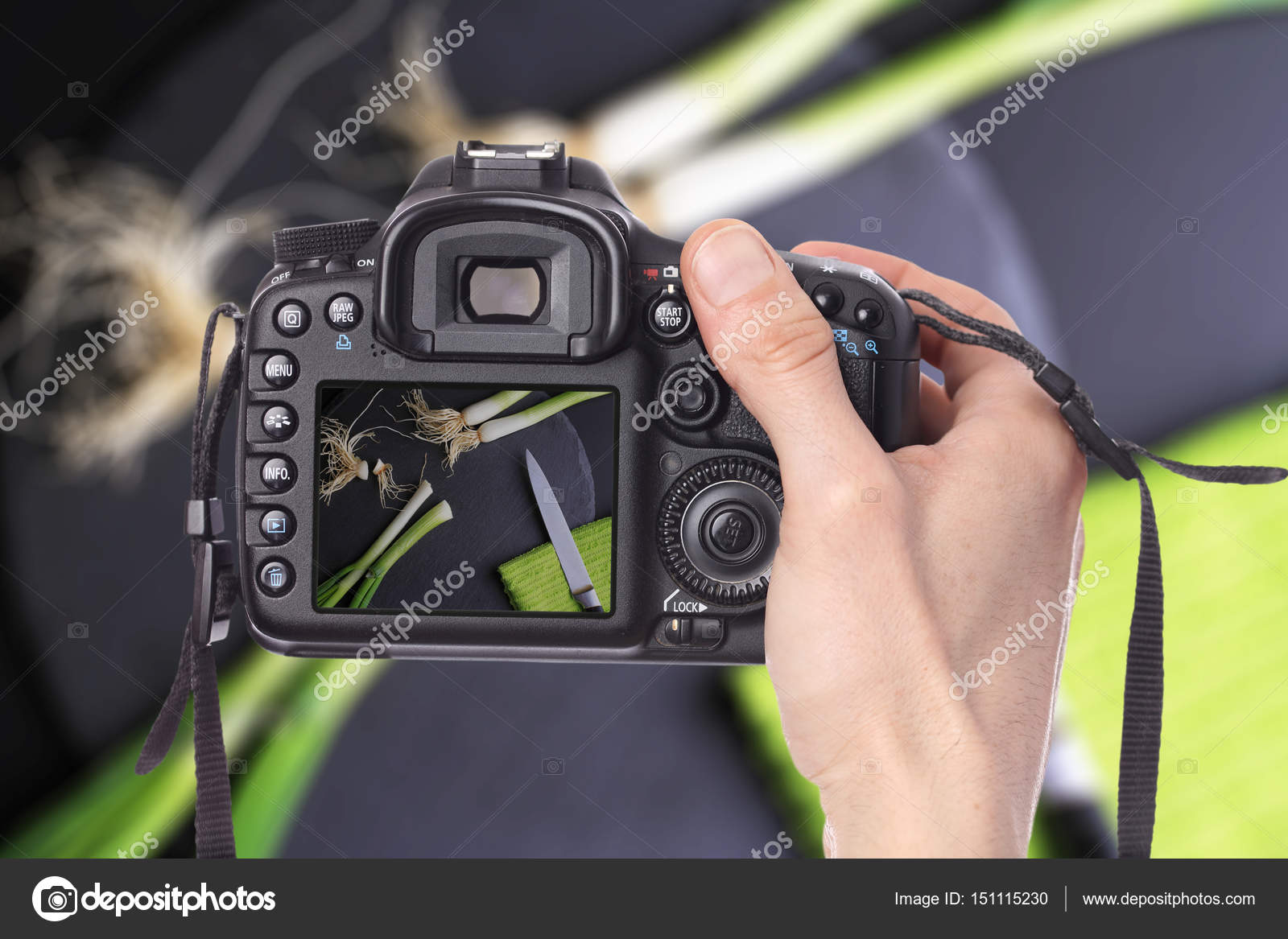 Male hand taking photo of green onion, on black background with ...