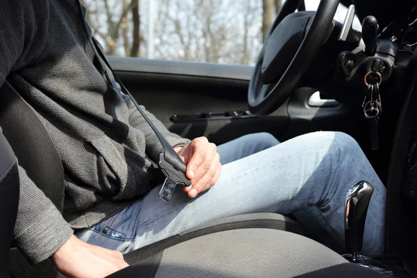 Conducir concepto de seguridad. Cierre del cinturón de seguridad del hombre en el coche — Foto de Stock