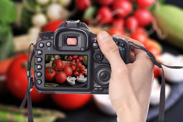 男手拍照的新鲜的、 生的、 有机的蔬菜，在黑色的背景，数码单反相机上。烹饪、 健康饮食概念. — 图库照片