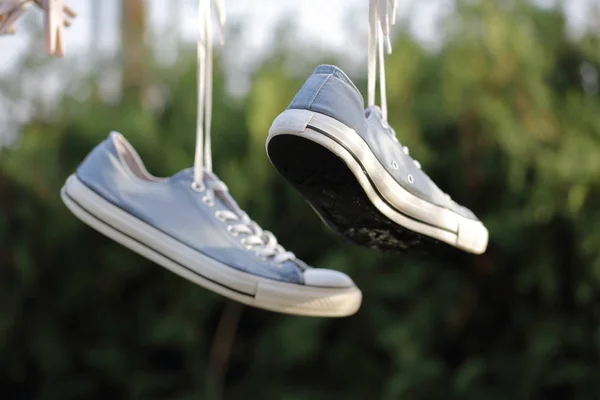 Zapatillas deportivas colgadas de la cuerda. Estilo de vida activo concepto fondo — Foto de Stock