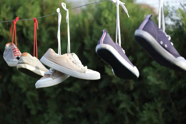 Zapatillas deportivas colgadas de la cuerda. Estilo de vida activo concepto fondo — Foto de Stock