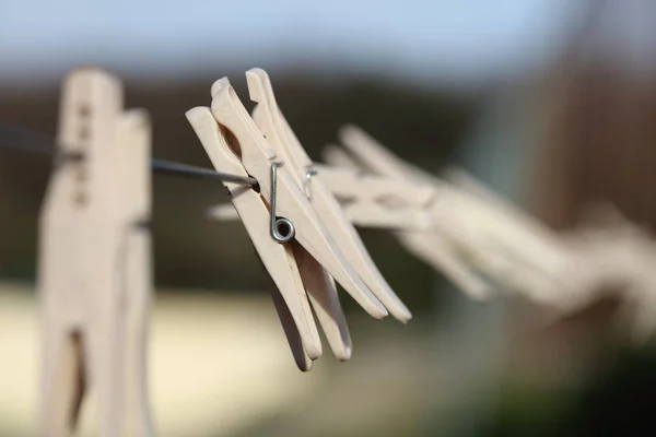 Pinces à linge en plastique gros plan accroché au fil de corde à linge . — Photo