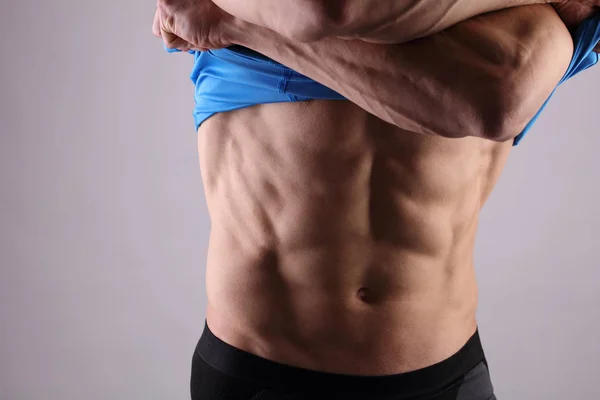 Homens musculosos, corpo perfeito, abdominais, seis alcateias. Um atlético forte a mostrar os abdominais. Musculação, esporte, fitness, treino, conceito de estilo de vida ativo . — Fotografia de Stock