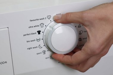 Kadın el ve kontrol panelindeki çamaşır makinesi, ultra beyaz düğmesini kapatın