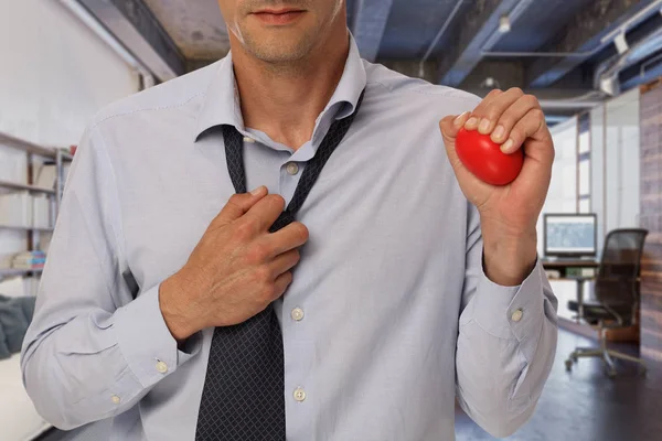 Stress relief concept. Skeptic and upset business man trying to calm down with anti stress rubber ball in an office.