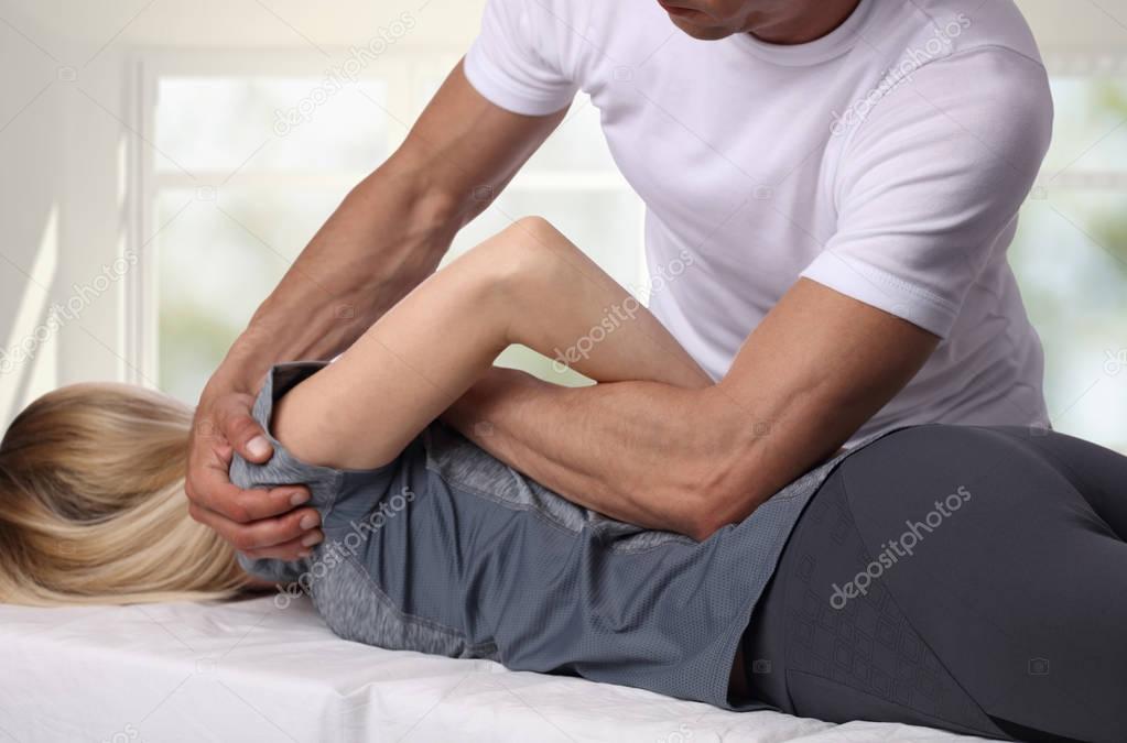 Woman having chiropractic back adjustment. Osteopathy, Acupressure, Alternative medicine, pain relief concept. Physiotherapy, sport injury rehabilitation