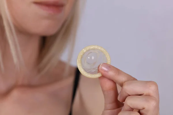 Woman holding condom close up. Contraception, Prevention of sexually transmitted diseases. Sexual health concept. — Stock Photo, Image