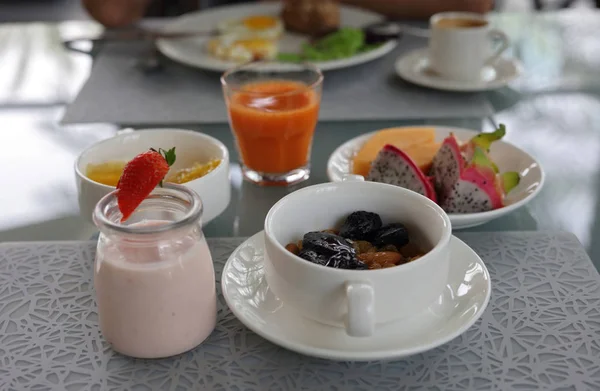 Desayuno saludable, concepto nutricional: yogur, frutas, nueces, jugo de zanahoria fresca, café. Dieta equilibrada —  Fotos de Stock
