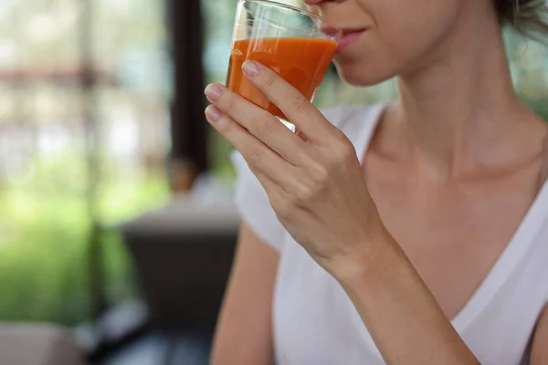 Gelukkig lachende vrouw drinken wortelsap close-up. Gezond eten en levensstijl concept — Stockfoto