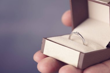 Nişan yüzüğü adam elinde. Adam holding mücevher kapatın. Aşk, evlenme teklifi, düğün, evlilik kavramı.