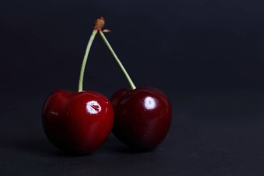 Kiraz siyah arka plan üzerine taze yakın çekim.