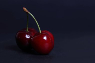 Kiraz siyah arka plan üzerine taze yakın çekim.