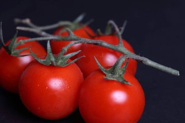 Kiraz domates siyah arka plan üzerine yakın taze yukarı.