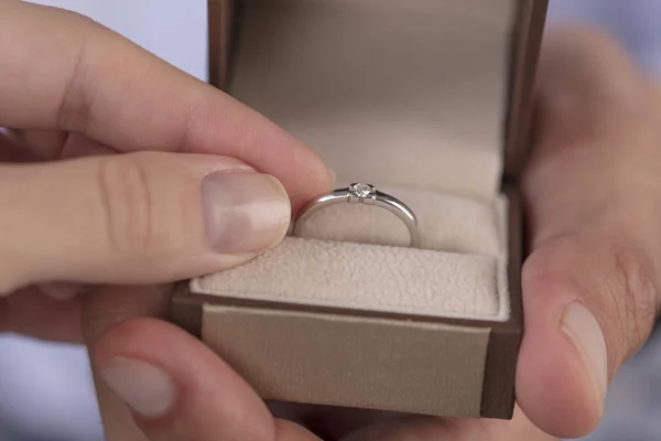 Förlovningsring i bruden händer. Kvinna anläggning smycken närbild. Kärlek, bröllop, föreslår, äktenskap koncept. — Stockfoto