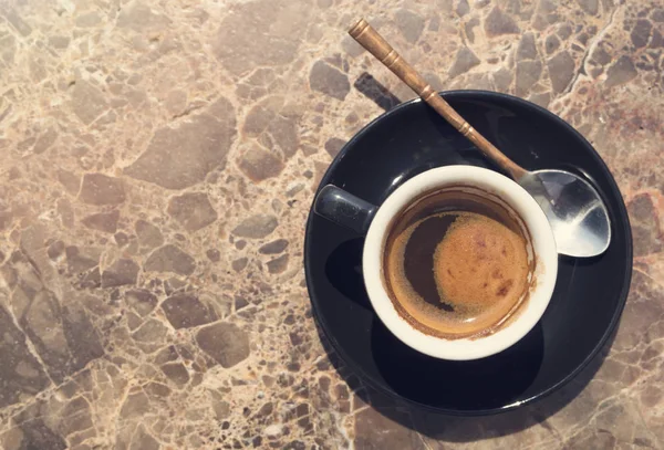 Una taza de café sobre una mesa de mármol. Foto vintage — Foto de Stock