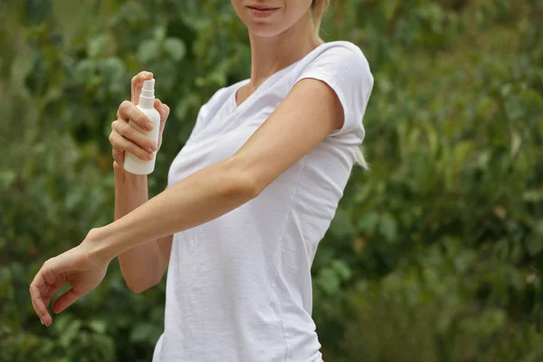 Repelente de mosquitos. Mujer usando spray repelente de insectos al aire libre . — Foto de Stock