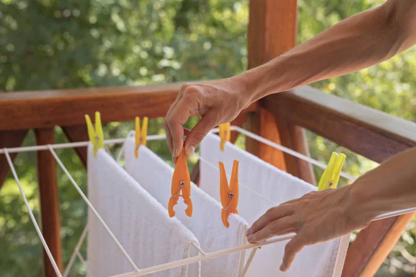 Laundry drying , clean white towels on a clothes horse outside.